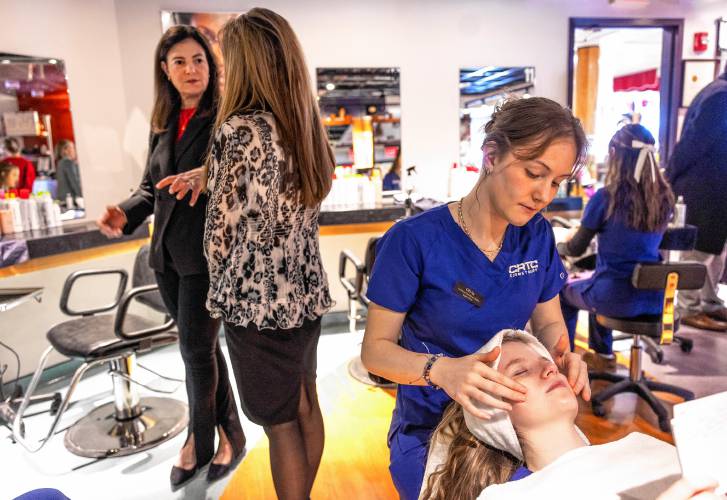 CRTC cosmetology student Olivia Syms works on giving fellow student Alice Barner a facial as Gov. Kelly Ayotte talks with cosmetology teacher Kimberly Hannon on Thursday.