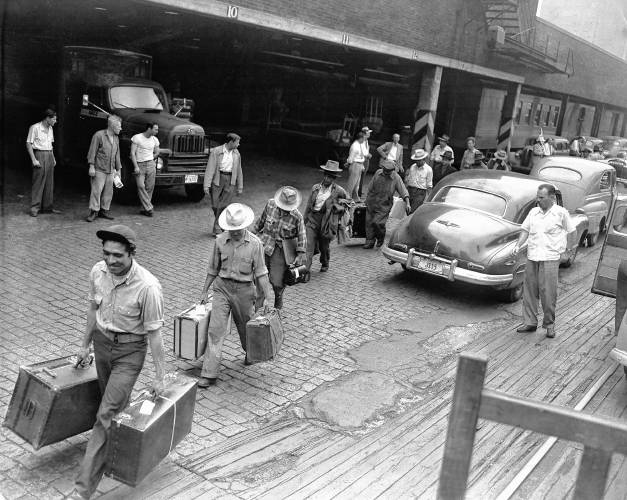 In this 1951 file photo, deported migrant farm workers carrying their belongings at a train station in Chicago. In this 1951 file photo, deported migrant farm workers carrying their belongings at a train station in Chicago.