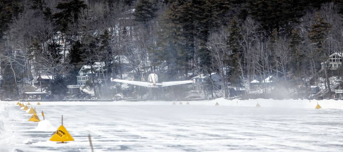 Visitors watch a plane takes off at the Alton Bay airstrip on Sunday, February 2, 2025. The ice must be at least a foot thick on Lake Winnipesaukee at the bay and the runway is a minimum of 2, 600 feet long and at least 100 feet wide.