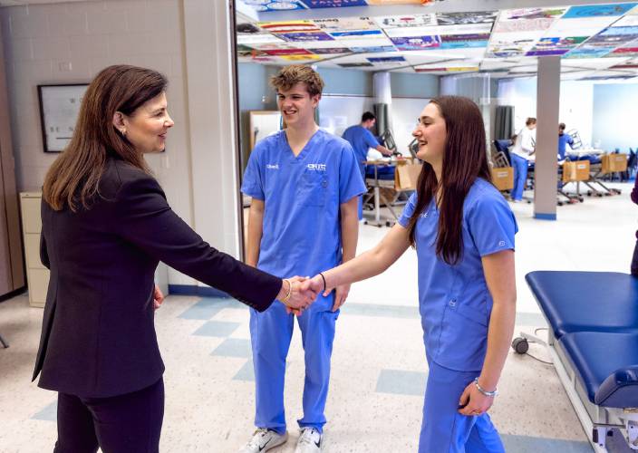 Governor Kelly Ayotte greets CRTC Culinary students Oliver Richert (center) and Emily Fauteux in the LNA certification program at Concord High School as she gets a tour of all the programs at the school on Thursday.
