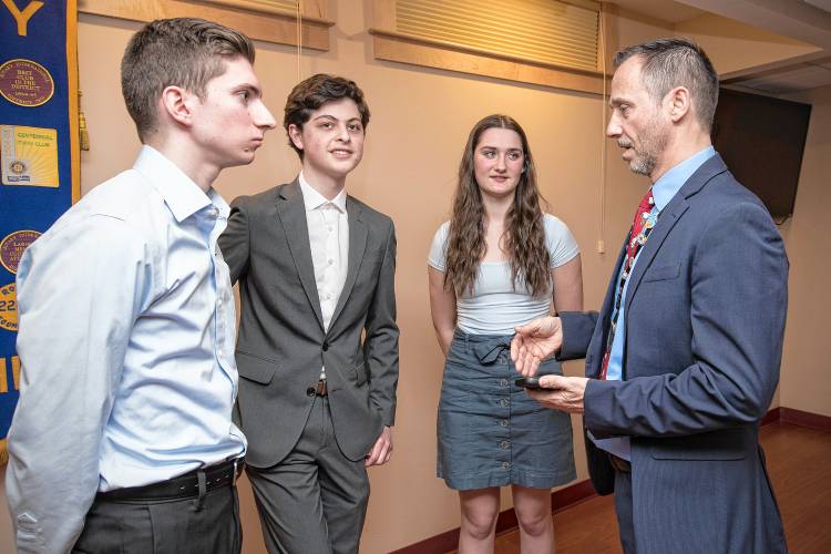 First place winner Joseph Albushies, second place winner Matthew Kropp and third place winner Emily Fauteux speak with Rotarian Ben Kiniry.