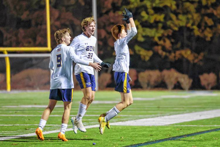 Luke Hartshorn (9) and Jake Reardon (32) join Colby Smith to pump up the student section after Smith’s goal gave the Falcons a 2-1 lead during Friday’s D-II championship game against Lebanon.