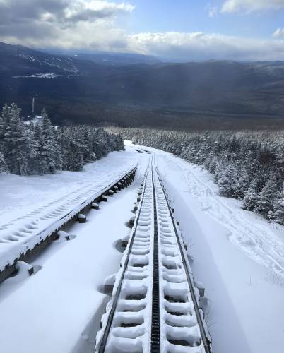 In this image provided by New Hampshire Fish and Game, snow covers the rails on the train tracks leading to the summit Mount Washington above the Cog Railway base station, Saturday, Feb. 17, 2024, in Mount Washington, N.H. A team of rescuers used the Cog Railway to shave off time but it still took more than 10 hours to save a hiker in conditions that included sustained winds topping 90 mph (145 kph) on New Hampshire's Mount Washington, officials said. (Conservation Officer Brad...