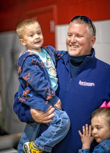 Select Board Chairman Ed Millette holds his grandson, Henry OâDonnell, 3, as his granddaughter Grace OâDonnell hugs him before the start of the Chichester Town Meeting at the elementary school on Saturday, March 15, 2024.