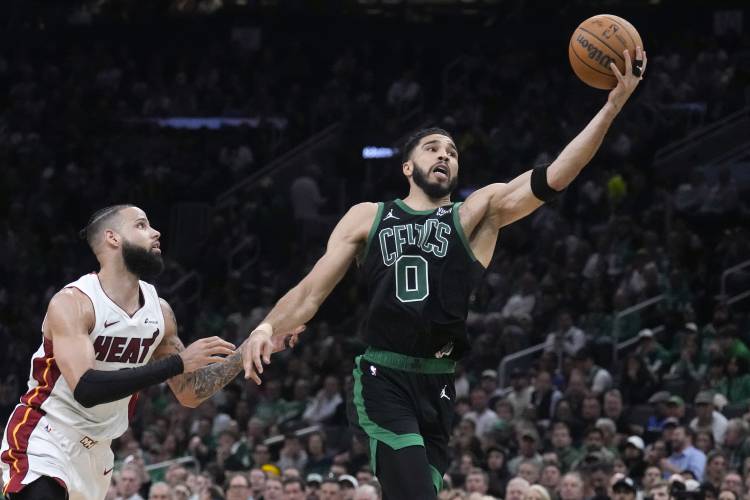 Boston forward Jayson Tatum (0) grabs a long pass over Miami defender Caleb Martin, left, during the first half of the Celtics’ NBA playoffs series sweep of the Heat on Wednesday.