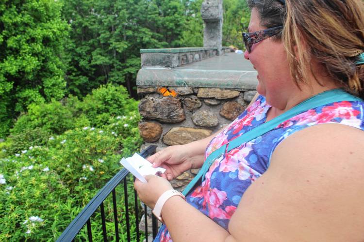 Kimberly Ferguson releases a Monarch butterfly in honor of her mother at Cathedral of the Pines on Thursday.