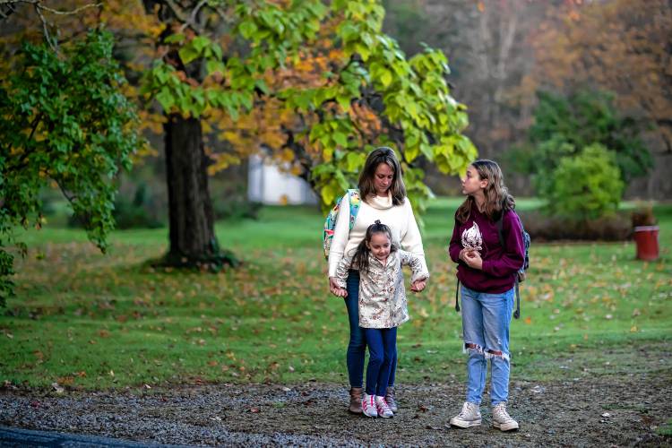 Abbie Teachout and her two young daughters, Piper (right) and Chloe, wait for the bus on New Rye Road in Epsom on Thursday.
