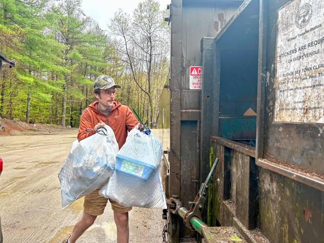 Andy Chew dumps his trash bags into the trailer at Wilmot’s transfer station on a Wednesday morning.