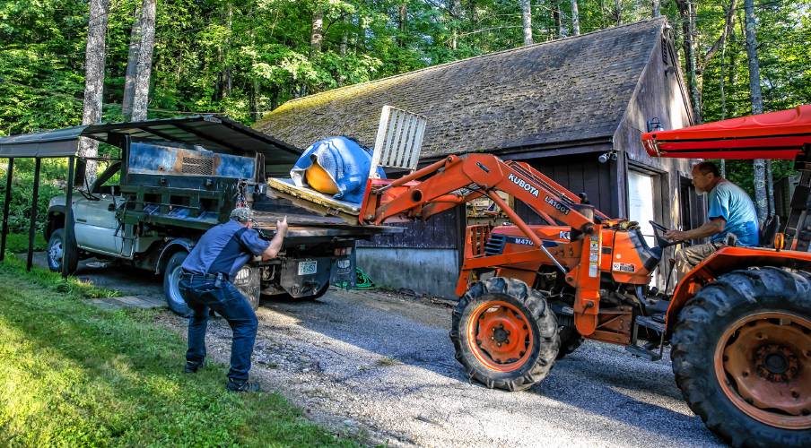  Nate Chartier guides John Lynch on his tractor as they put the giant pumpkin onto Nateâs truck on Wednesday, August 28, 2024 so that they can deliver it to the Hopkinton Fair for judging.