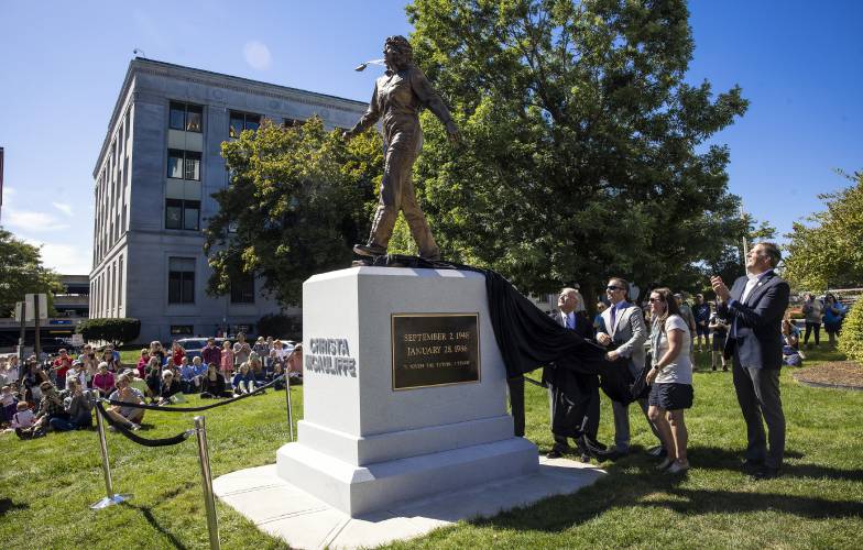 Steven McAuliffe and his children, Scott and Caroline, unveil the statue of Christa McAuliffe as Gov. Chris Sununu looks on at the dedication on the State House grounds on Monday, September 2, 2024.