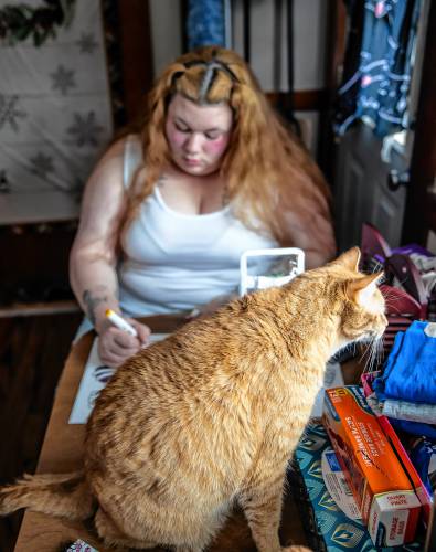 Brie Lamarche works on coloring in her kitchen of her apartment in Rochester. Lamarche says the coloring calms her along with her three cats which keeps her centered.