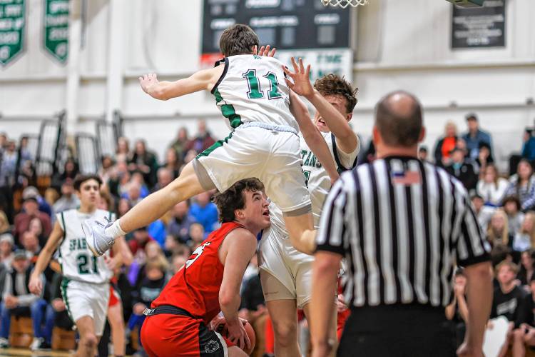 Coe-Brown’s Jack Matson contends with Pembroke sophomore Zach Bemis (11) leaping in front of him during Monday’s 65-47 win for Pembroke.