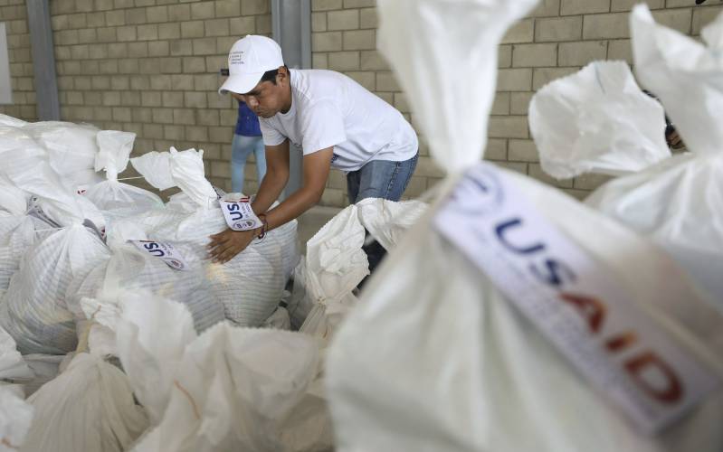 A Venezuelan volunteer places a bag of USAID humanitarian aid for storage at a warehouse near Cucuta, Colombia, on the border with Venezuela, Friday, Feb. 8, 2019.