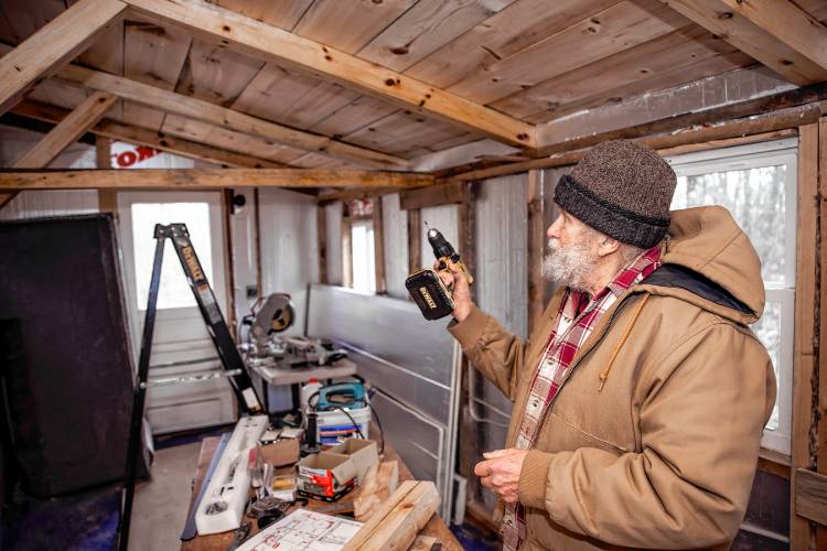 Woodworker David Emerson prepares to drill to attach support beams of the tiny house he is modeling on his Canterbury property.