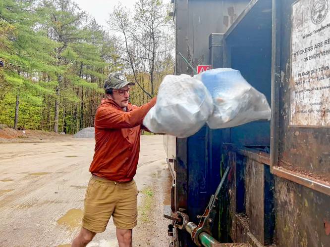 Andy Chew dumps his trash bags into the trailer at Wilmot’s transfer station on a Wednesday morning