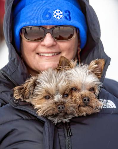 Christine Bogacz holds her dogs, Moose and Ham inside her coat as she watches the planes at the Alton Bay airport on Sunday, February 2, 2025.