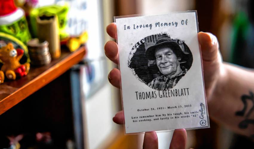 Brie Lamarche holds the memorial card for her grandfather, Thomas Greenblatt that she keeps in a special case in her kitchen.