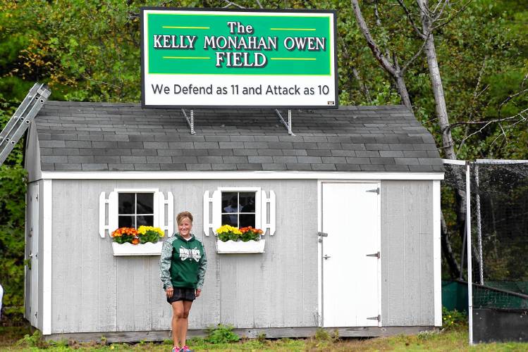 Bishop Brady field hockey coach Kelly Owen stands under a new sign honoring her 30 years of coaching. Owen was named the Division III Coach of the Year.