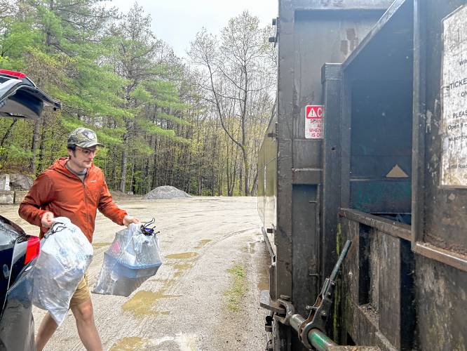 Andy Chew dumps his trash bags into the trailer at Wilmot’s transfer station on a Wednesday morning