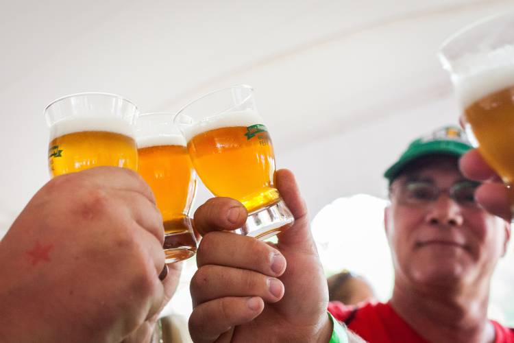 A group makes a toast before drinking a sample of craft beer at the New Hampshire Brewers Festival at Kiwanis Riverfront Park in Concord on Saturday, July 22, 2017. (ELIZABETH FRANTZ / Monitor staff)