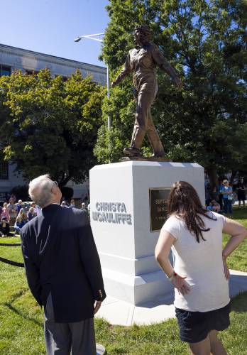 Steven McAuliffe and his daughter, Caroline, look up at the Christa McAuliffe statue at the dedication in her honor on Monday.