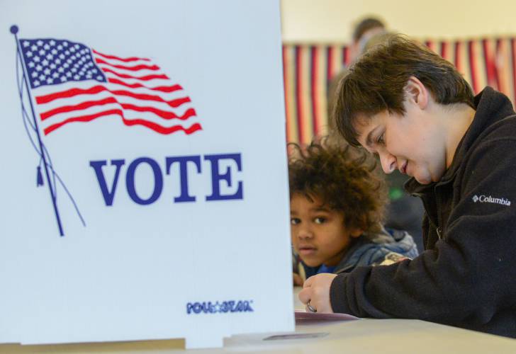 Levi Canon, 5, of Chesterfield, N.H., watches his mother, Bethany, fill out her ballot in the New Hampshire primary on Tuesday, Jan. 23, 2024. (Kristopher Radder /The Brattleboro Reformer via AP)