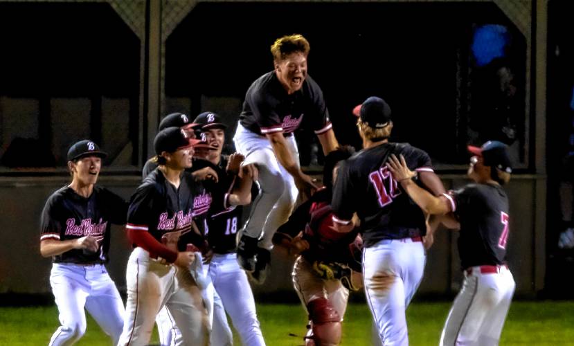 Belmont senior Hutch Haskins leaps in the air as he leads the team in congratulating pitcher Anakin Underhill (17) after he led the Red Raiders beat Conant in the Div. III semifinals on Tuesday night, June 4, 2024 at Robbie Mills Stadium in Laconia.