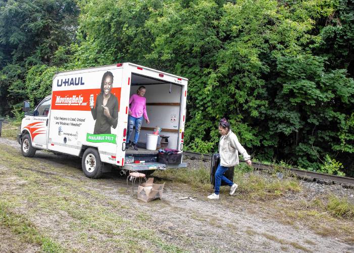 A friend helps Melissa pack her U-Haul before Concord police arrived to clear out her homeless encampment behind Robin Bach’s backyard on Tuesday.