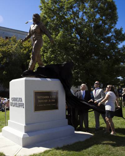 Steven McAuliffe and his children, Scott and Caroline, unveil the statue of Christa McAuliffe at the dedication on the State House grounds on Monday.