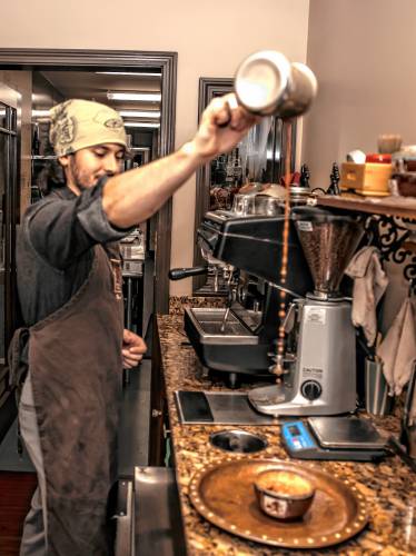 Chocolate maker Roger Balcom pours a Olmec Drinking Chocolate into a mug at the Dancing Lion Chocolate on Elm Street in downtown Elm Street on Wednesday, October 30, 2024.