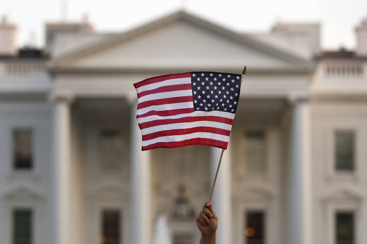 In this Sept. 2017 file photo, a flag is waved outside the White House, in Washington. In this Sept. 2017 file photo, a flag is waved outside the White House, in Washington.