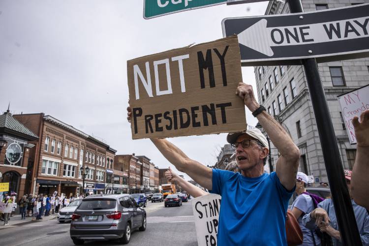 Jeff Protentis from Groton, Massachusetts came to protest at the ‘Hands Off’ event at the State House in downtown Concord on Saturday, April 19, 2025.