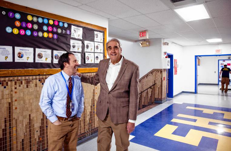 Former Franklin assistant principal Bill Athanas talks with the current principal David Levesque in the hallway of the high school on April 9. Athanas saw the sign, worn and tired, outside Franklin High School and decided to update it.