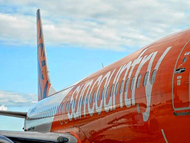The first Sun Country Airlines plane to land at Manchester-Boston Regional Airport shows its orange, white and blue livery with the carrier’s logo on the tail fin.