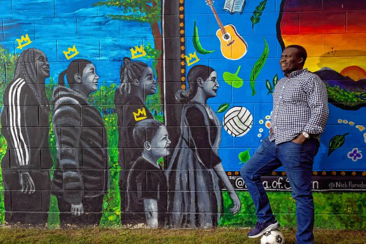 Jean Hakuzimana, founder and director of the organization NH Songa, in front of the mural at Keach Park, the site of the Multicultural Festival on Sunday. Hakuzimana feels the park is the center for the New American culture in Concord.