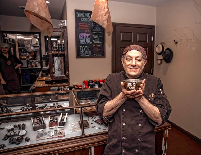 Richard Tango-Lowy, owner of Dancing Lion Chocolate, takes a sniff of his Olmec Drinking Chocolate at his store on Elm Street in Manchester on Wednesday. Luxury Travel Guide named Dancing Lion Chocolate the 2024 Top Confectionery Store in the world.