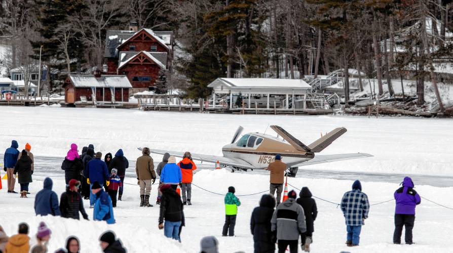 Visitors watch a plane takes off at the Alton Bay airstrip on Sunday, February 2, 2025. The ice must be at least a foot thick on Lake Winnipesaukee at the bay and the runway is a minimum of 2, 600 feet long and at least 100 feet wide.