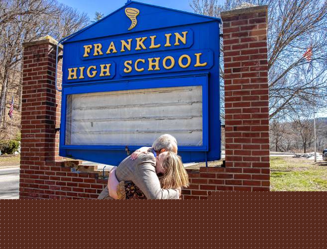 Former Franklin assistant principal Bill Athanas hugs teacher Jule Finley outside the current Franklin High School sign last week. 