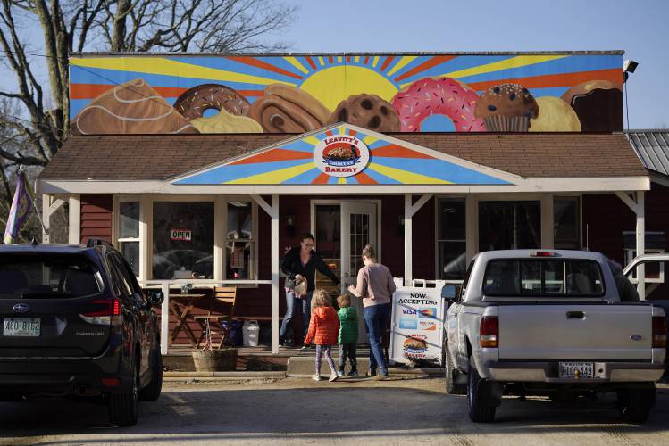 FILE - A customer holds the door for a family arriving at Leavitt's Country Bakery in this April 13, 2023 file photo, in Conway, N.H. (AP Photo/Robert F. Bukaty, file)
