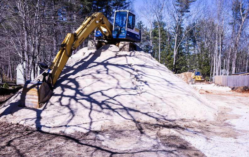 An excavator sits on top of a mound of sand at a house construction on Abbott Road on April 4. An excavator sits on top of a mound of sand at a house construction on Abbott Road on April 4.