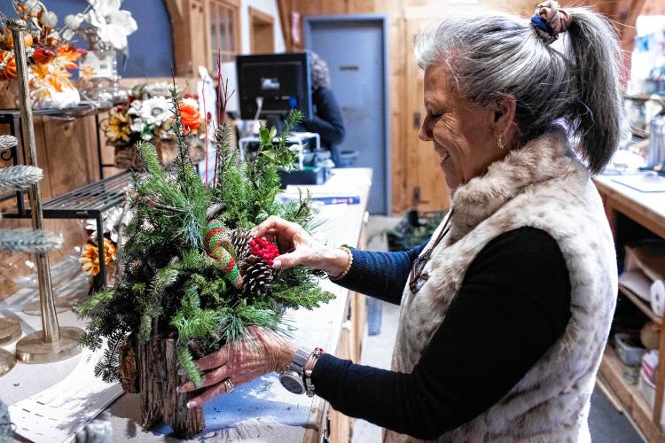 Jane Iarussi, vice president of Cole Gardens in Concord, puts the final touches on a custom made Christmas log basket she named the Pizzazz Christmas Basket on Tuesday, November 28, 2023. Iarussi says sheâs grateful there is an extra week between Thanksgiving and Christmas this year.