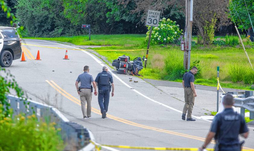 Concord police look over a motorcycle crash scene where the driver was killed on Washington Street in Penacook across from Fowler Street on Monday afternoon, July 15, 2024.