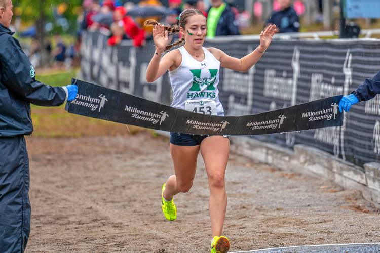 Hopkinton’s Maddy Lane breaks the tape to win the Girls’ Small School Race at the Manchester Invitational at Derryfield Park on Saturday. Lane topped a field of over 200 runners and the Hawks finished third at the 110-team event. Over 50 of those teams competed in the small school race.