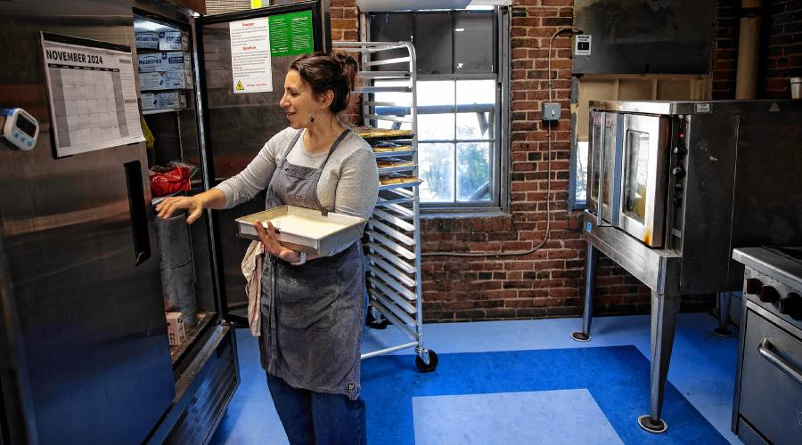 Chelsea Annett gets items out of her industrial refrigerator in her kitchen at Table on Wednesday, November 20, 2024. Annett opened Table, located in Concord’s Eagle Square, in July.