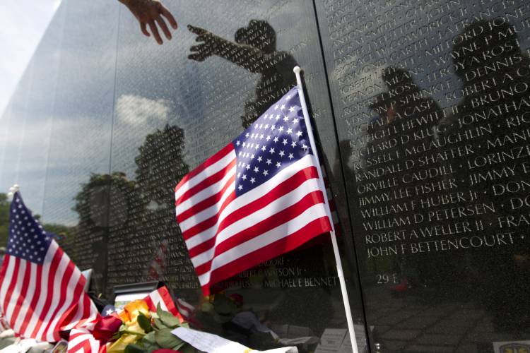 Visitors look at the names at the wall of the Vietnam Veterans Memorial in Washington, Monday, May 25, 2015, during Annual Memorial Day Observance ceremony.  (AP Photo/Jose Luis Magana)