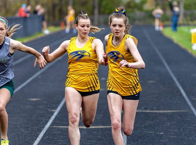 Bow’s Cara Van Dyke (left) hands off to teammate Camden Wilson (right) during the 4x100-meter relay at Bow High School on Saturday. Bow won the relay in a season-best time of 53.01 seconds and went on to defeat Pembroke and Kingswood in the tri-meet.