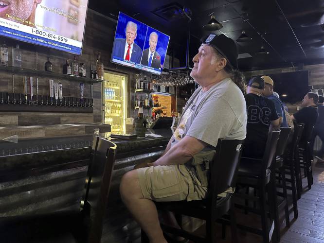 Veteran Hector Mercado, 72, watches the presidential debate in a crowded McAllen, Texas bar Thursday, June 27, 2024. Although he was a Democrat for several years, he switched parties under Reagan. Mercado heard the allegations Biden raised about Trump's derogatory comments about veterans, but it didn't sway his support. 
