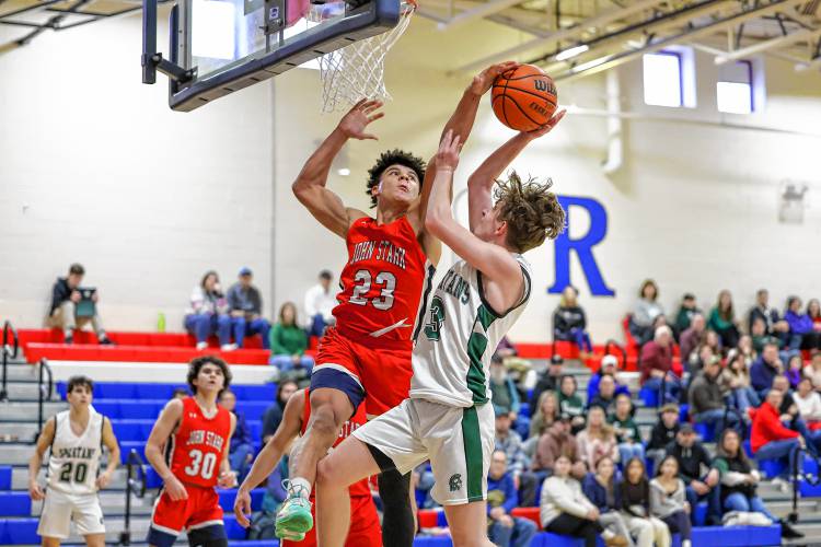 John Stark’s Donnie White (23) blocks a shot by Pembroke’s Jacob Mather (3) during the boys’ third-place game of the Capital Classic holiday basketball tournament on Friday night.