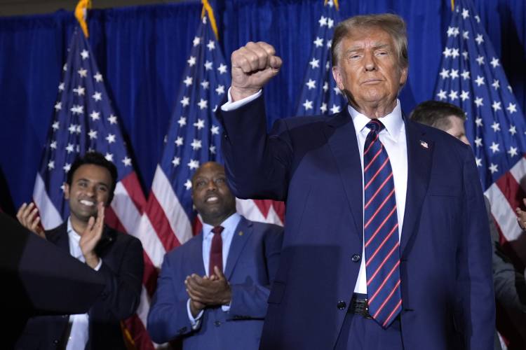 Republican presidential candidate former President Donald Trump reacts after speaking at a primary election night party in Nashua, N.H., Tuesday, Jan. 23, 2024. At left are Vivek Ramaswamy and Sen. Tim Scott, R-S.C. (AP Photo/Matt Rourke) 