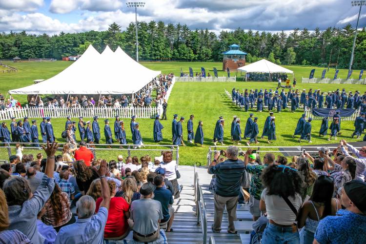 As family and friends wave and take videos, the 2024 Merrimack Valley graduating class file into the athletic fields behind the school on Saturday morning, June 8. 2024.